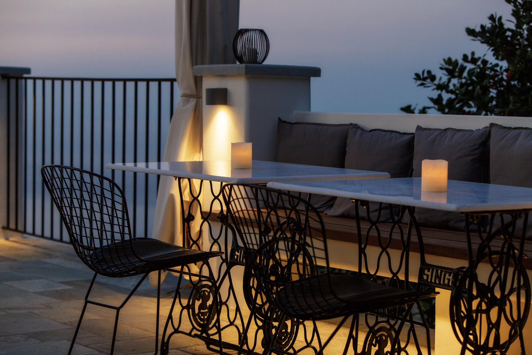 Μοντέρνα ταράτσα με μαρμάρινα τραπέζια και πανοραμική θέα στο Αιγαίο. Minimal rooftop featuring marble tables and serene modern ambiance with panoramic Aegean Sea views.