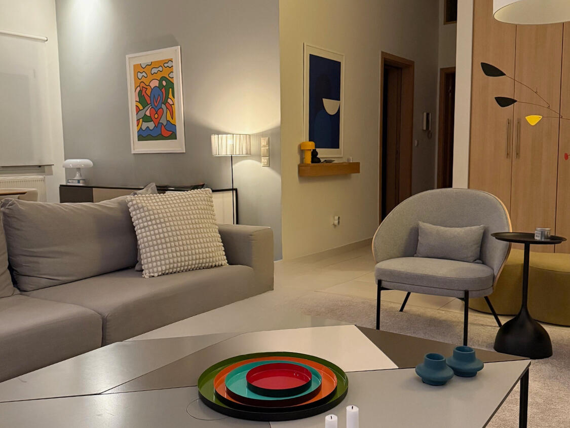 Φωτεινό καθιστικό σκανδιναβικού στυλ με μινιμαλιστική επίπλωση, φυσικό ξύλο, άνετο καναπέ και πολυθρόνες. Bright Scandinavian-style living room with minimalist furniture, natural wood, comfortable sofa and armchairs.